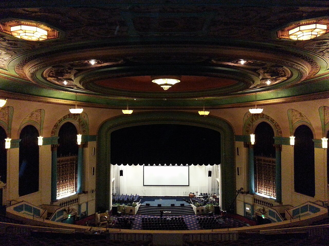 Cinema auditorium with a screen and rows of seats.