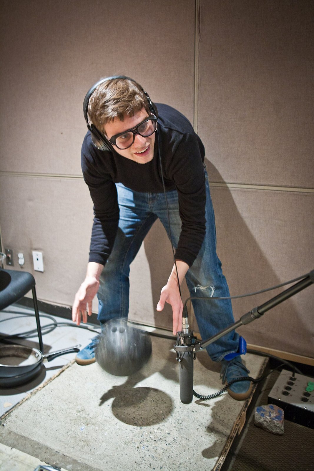 Foley artist working with a prop in front of a microphone.