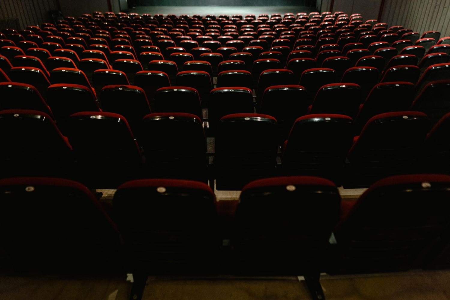 Empty cinema auditorium with red and black seating.