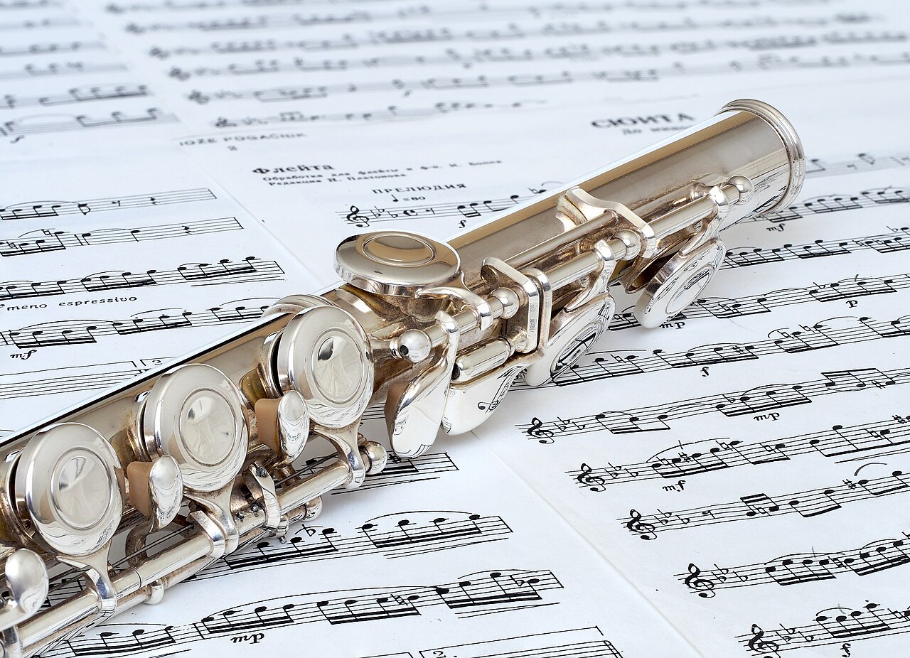 Flute on sheet music as an example of a woodwind instrument.