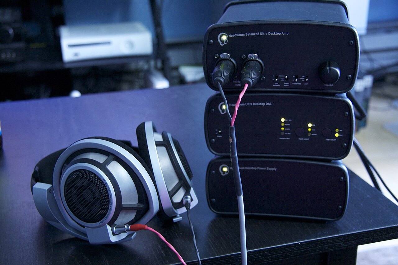 Headphones beside a DAC and headphone amplifier.