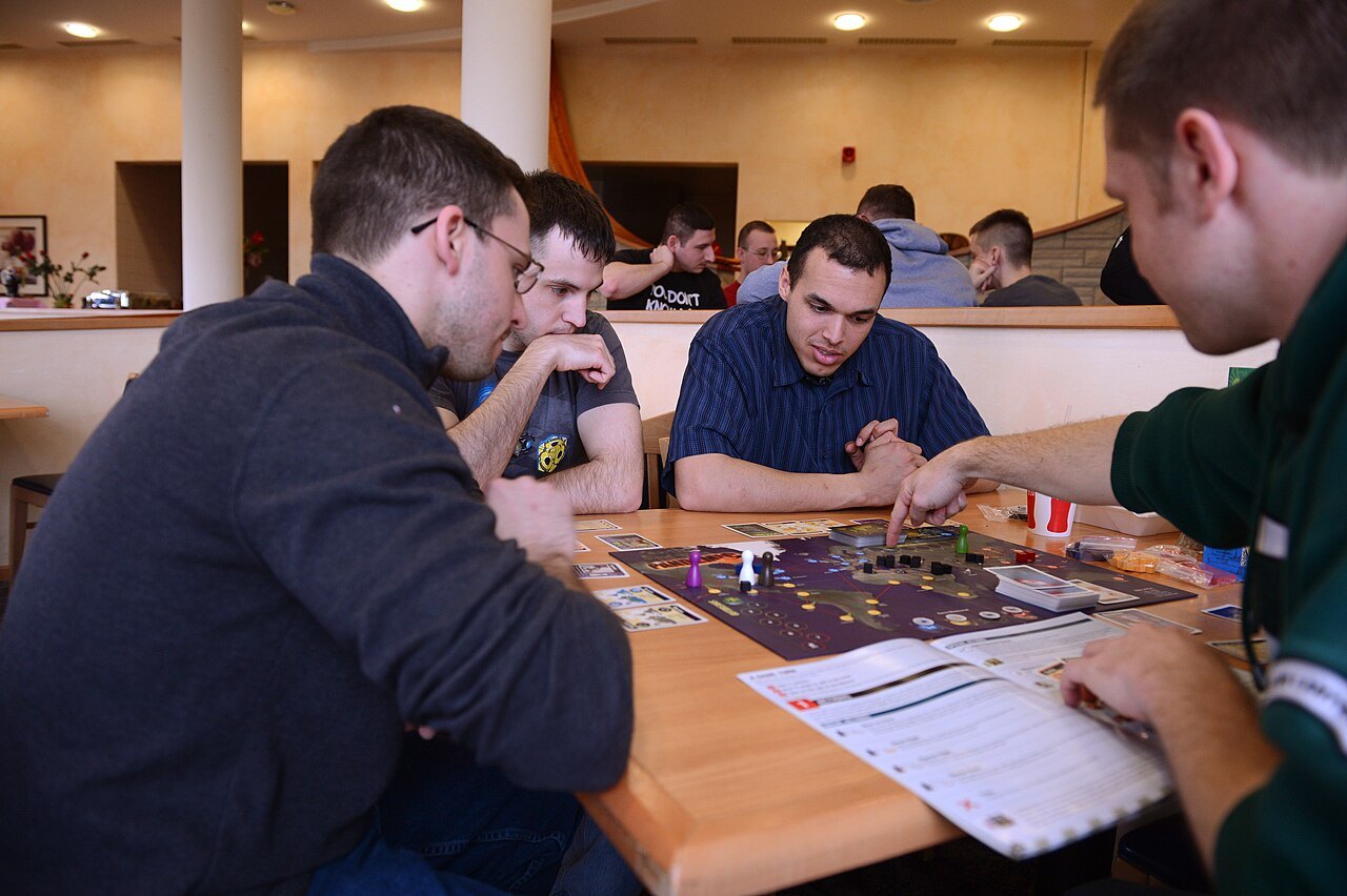 A group playing the cooperative board game Pandemic.