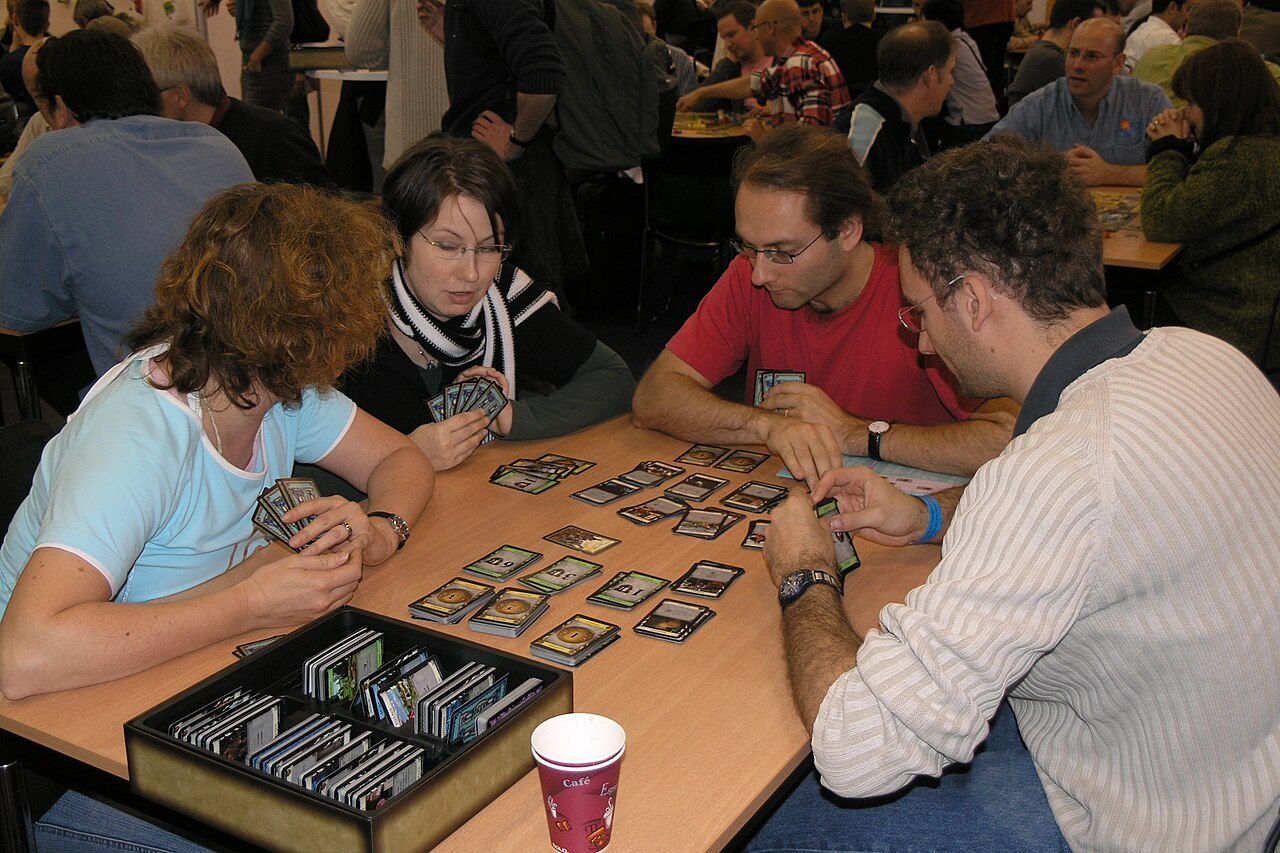 Players taking part in the deckbuilding card game Dominion.