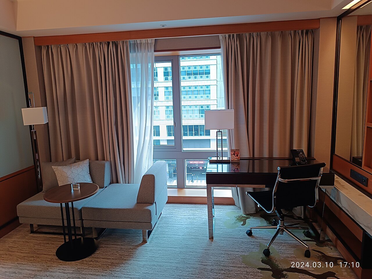 Living area with large windows and curtains that can be drawn.