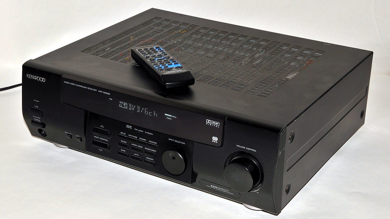 AV receiver with its remote control resting on the case.