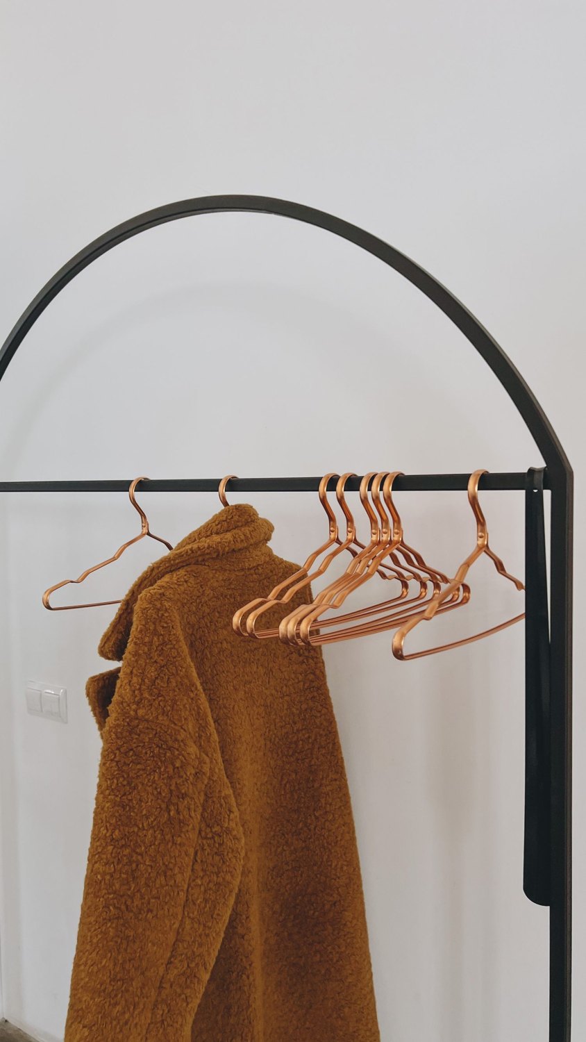 Coat and empty hangers on a clothes rail.