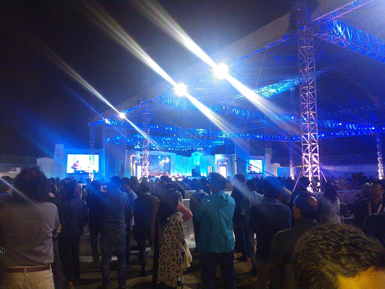 Audience in front of an illuminated festival stage.