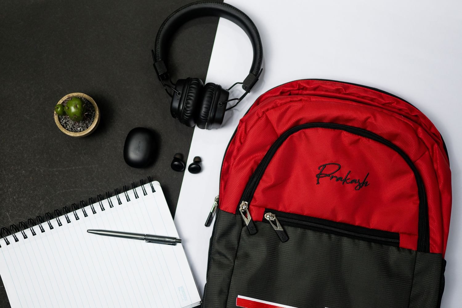 Backpack, headphones and notebook laid out before packing.